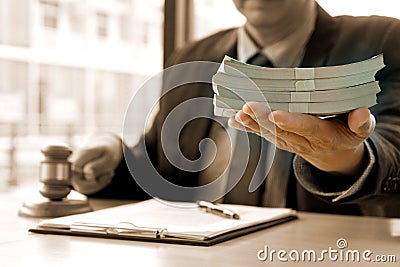 judge one hand receive money and another hand holding gavel Stock Photo